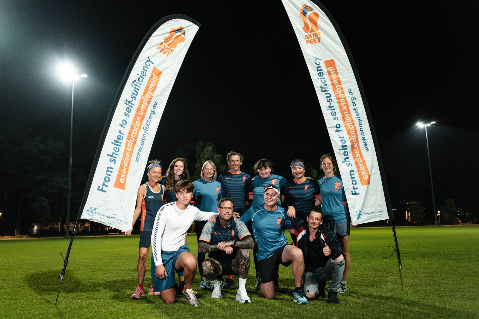 The On My Feet community together at evening training under lights